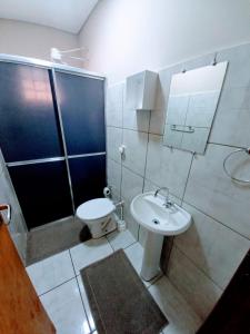 a bathroom with a toilet and a sink and a shower at Residencial JOED 3 in Dourados
