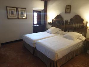 A bed or beds in a room at Parador de Plasencia