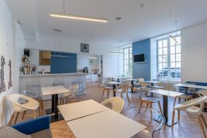a cafeteria with tables and chairs and a kitchen at Hotel François 1er Cœur de Ville in La Rochelle +25 photos