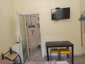 um quarto com uma mesa e uma televisão na parede em Smart yellow apartment-15 хв від жд вокзалу em Lviv