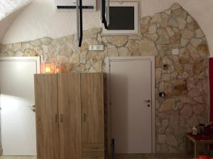 una stanza con un muro in pietra e una televisione di La Pietra a Bari