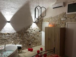 bagno con parete in pietra, vasca e lavandino di La Pietra a Bari