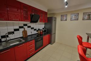 a kitchen with red cabinets and a sink at Battle Mile Hostel in Cherkasy