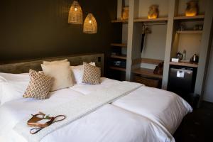 a white bed with a book on top of it at Olive Grove Guesthouse in Windhoek