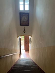 un corridoio con finestra e orologio sul muro di Tenuta Fagnanetto a Santo Stefano Belbo