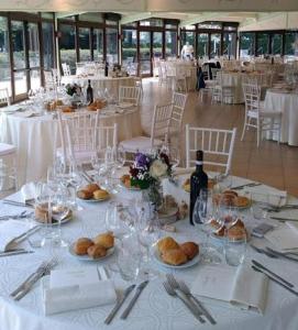 - une longue table avec des assiettes de nourriture et des verres à vin dans l'établissement Hotel Novarello Resort & Spa, à Granozzo con Monticello