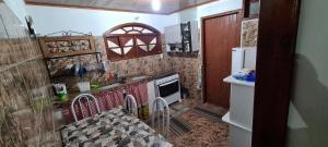 a small kitchen with a stove and a refrigerator at Casa no Arraial do Sana in Sana