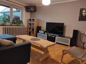 - un salon avec une table basse et une télévision à écran plat dans l'établissement Apartament Pod Taborem, à Niedzica