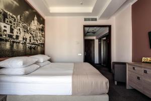 
a hotel room with a bed and a painting on the wall at Rius Hotel Lviv in Lviv
