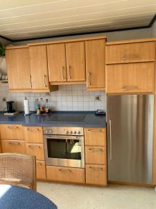 a kitchen with wooden cabinets and a stainless steel refrigerator at Andrea's Ferienwohnung in Brietlingen