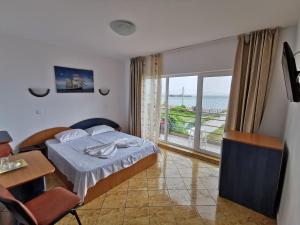a bedroom with a bed and a view of the ocean at ADONIS Costinesti in Costinesti