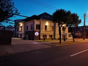 a white building on a street at night at English House in Bistriţa