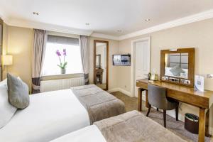 a hotel room with a bed and a desk at Gem Langham Court Hotel in London +93 photos