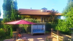 a patio with an umbrella and a blue chair at B&B Naturin - Cascina Colombaro in Lauriano