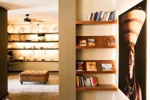 a living room with a book shelf with books at Olive Grove Guesthouse in Windhoek