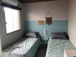 a bedroom with two beds and a window at Casa Ampla a 300 metros de uma das melhores praia de SSA in Salvador +13 photos