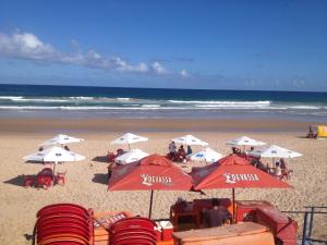 a beach with umbrellas and chairs and the ocean at Casa Ampla perto de uma das melhores praia de SSA in Salvador