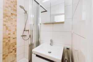 a white bathroom with a sink and a shower at Sonne-Strand-Binz in Binz