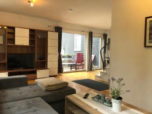 a living room with a couch and a television at Fewo Zentral in Willingen