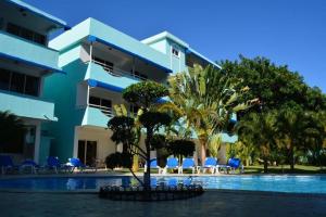 un edificio con piscina al lado de un complejo en New Garden Hotel en Sosúa