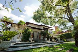 a house with a courtyard with palm trees at Casa Flora Garden & Pool in Carapicuíba