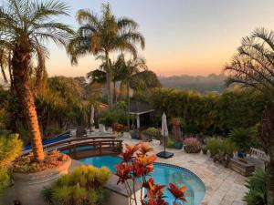a resort with a swimming pool and palm trees at Casa Flora Garden & Pool in Carapicuíba