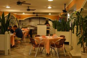 un restaurante con mesas con gente sentada en ellas en New Garden Hotel, en Sosúa