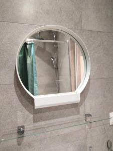 a round mirror on a wall in a bathroom at Miltos rooms in Leptokarya +37 photos