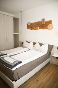 two beds in a room with white walls and wood floors at Alloggio Casa Talvena Longarone in Longarone