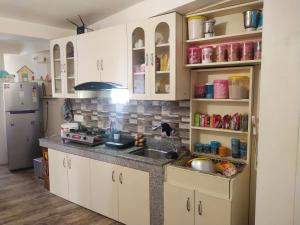 una cocina con armarios blancos y fregadero en SASHI HOME a Cupid Destination en Darjeeling