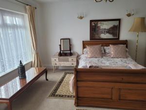 a bedroom with a bed and a table and a mirror at Sandy Retreat in Worle