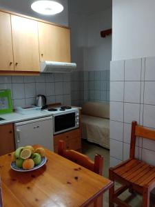una cocina con una mesa con un plato de fruta. en Joanna studios -apartment en Acharavi