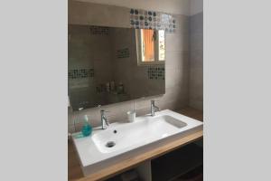 un bagno con lavandino e specchio di Escapade en Périgord a Villefranche-du-Périgord