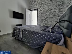 ein Schlafzimmer mit einem Bett und einer Ziegelwand in der Unterkunft Logement avec Spa Privatif Jacuzzi Grande terrasse sans vis à vis Sky House Agen in Agen