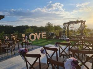 a row of chairs with a love sign in the background at Leshtenski Rai Guest House in Leshten