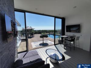 ein Wohnzimmer mit einem Balkon mit Poolblick in der Unterkunft Logement avec Spa Privatif Jacuzzi Grande terrasse sans vis à vis Sky House Agen in Agen