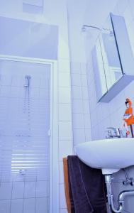 La salle de bains blanche est pourvue d'un lavabo et d'une douche. dans l'établissement Berlin Apartments Mitte, à Berlin