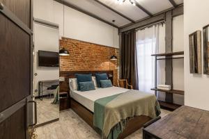 sypialnia z łóżkiem i ścianą z cegły w obiekcie Waou Boutique SOL w Madrycie