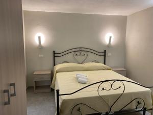 Un dormitorio con una cama con dos luces en la pared. en Case Vacanze Seggettieri, en Palermo 21 fotos más