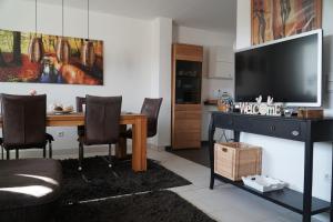 a living room with a dining room table with a television at Ferienwohnung Eschendorf in Rheine
