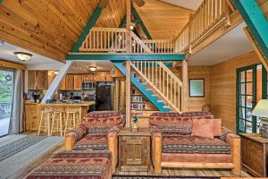 uma sala de estar com sofás e uma escadaria em Overgaard Cabin with Hot Tub, Fire Pit and Deck! em Overgaard