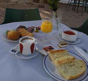 einen Tisch mit einem Frühstück mit Toast, Kaffee und Orangensaft in der Unterkunft Hotel El Zorro in Barranda