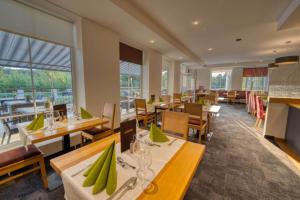 un restaurant avec des tables, des chaises et des fenêtres dans l'établissement Hotel & SPA Reibener-Hof, à Konzell