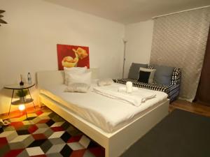 een wit bed in een kamer met een bank bij City West Studios in Stuttgart