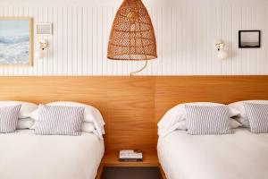 Pokój z 2 łóżkami i lampką na ścianie w obiekcie Bluebird Parker Beach Lodge w mieście South Yarmouth