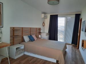 ヴァルナ・シティにあるSoulful Apartments - Horizonのベッドルーム1室(ベッド1台、デスク、窓付)