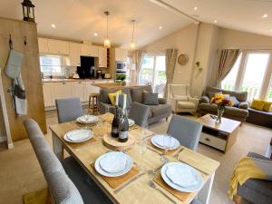 a living room with a dining table and a kitchen at Meadow Lodge in Scarborough