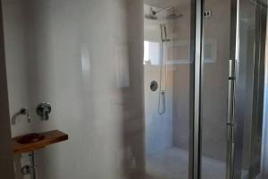 a shower in a bathroom with a glass shower stall at Casetta da scoprire a due passi dal centro in Tortolì
