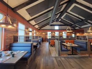 ein Restaurant mit blauen Stühlen und Tischen und einer Ziegelwand in der Unterkunft Amsterdam Inn & Suites Florenceville in Florenceville