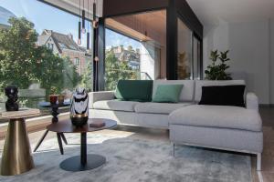 un soggiorno con un divano e un tavolo di Boulevard Botanie city apartment with parking a Hasselt